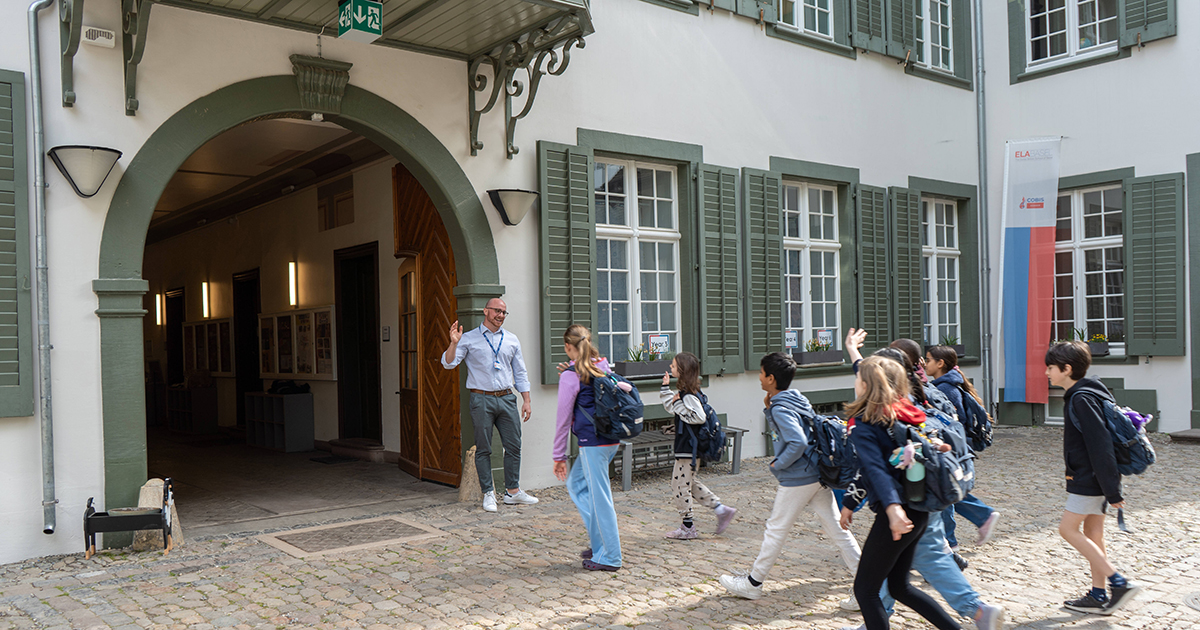 School leader welcoming students at ELABasel in Basel